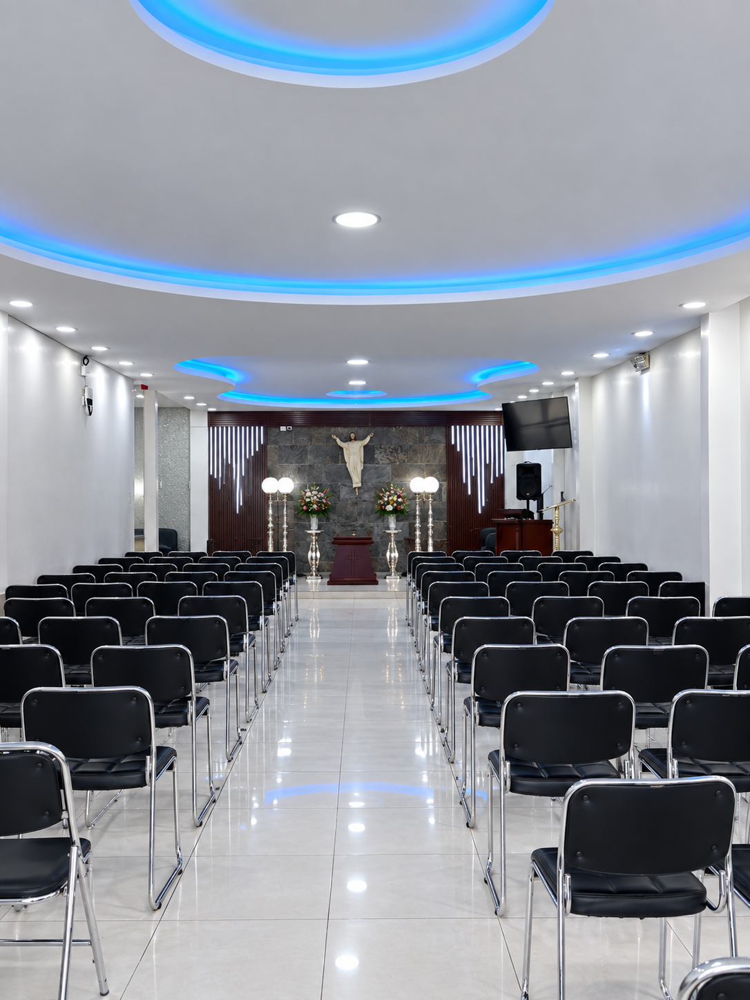 Recepción elegante de funeraria con mostrador de mármol, flores frescas blancas, iluminación cálida, ambiente profesional y acogedor