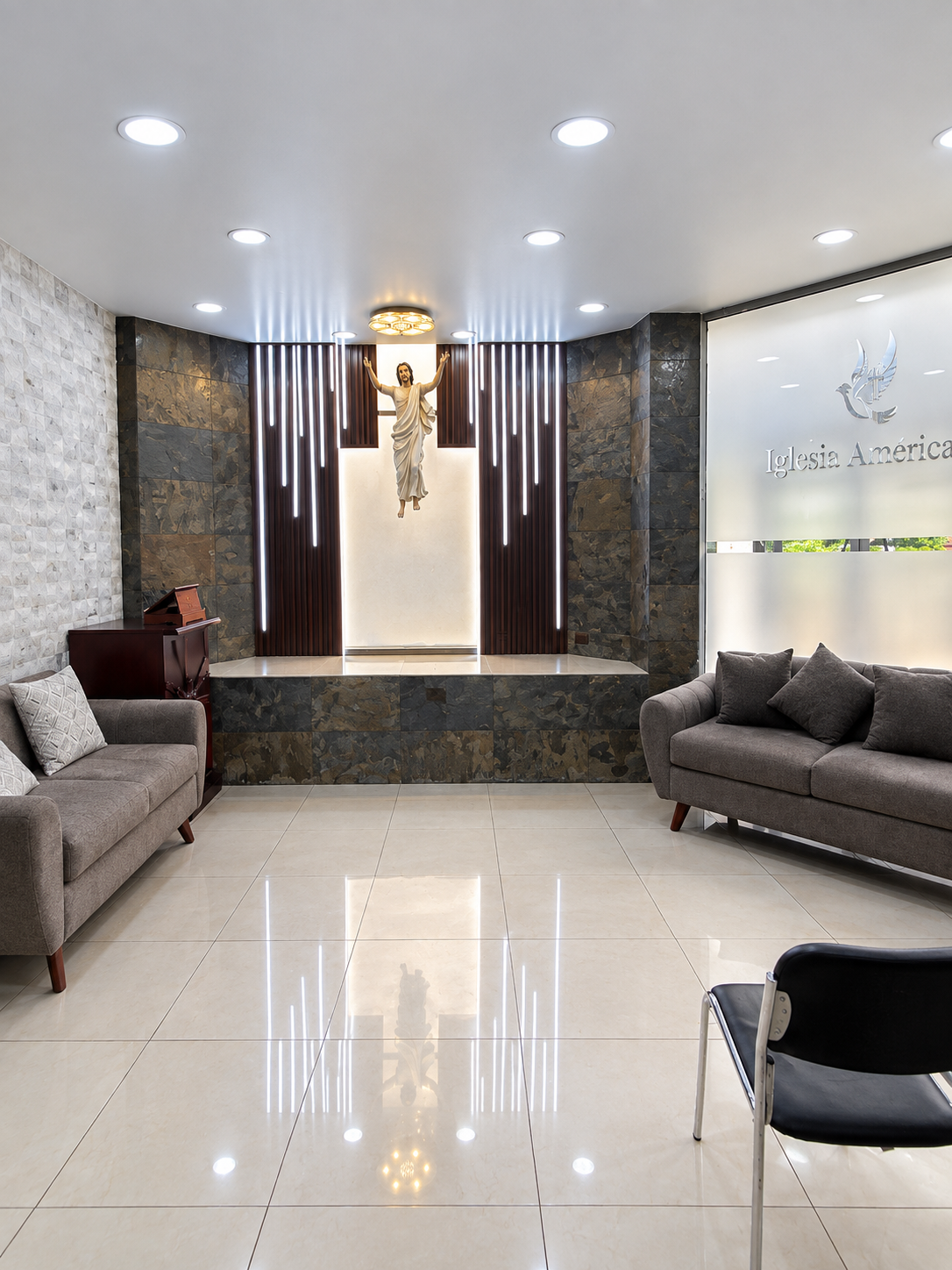 Corredor interior con iluminación suave, paredes blancas y cuadros decorativos, ambiente de serenidad y dignidad